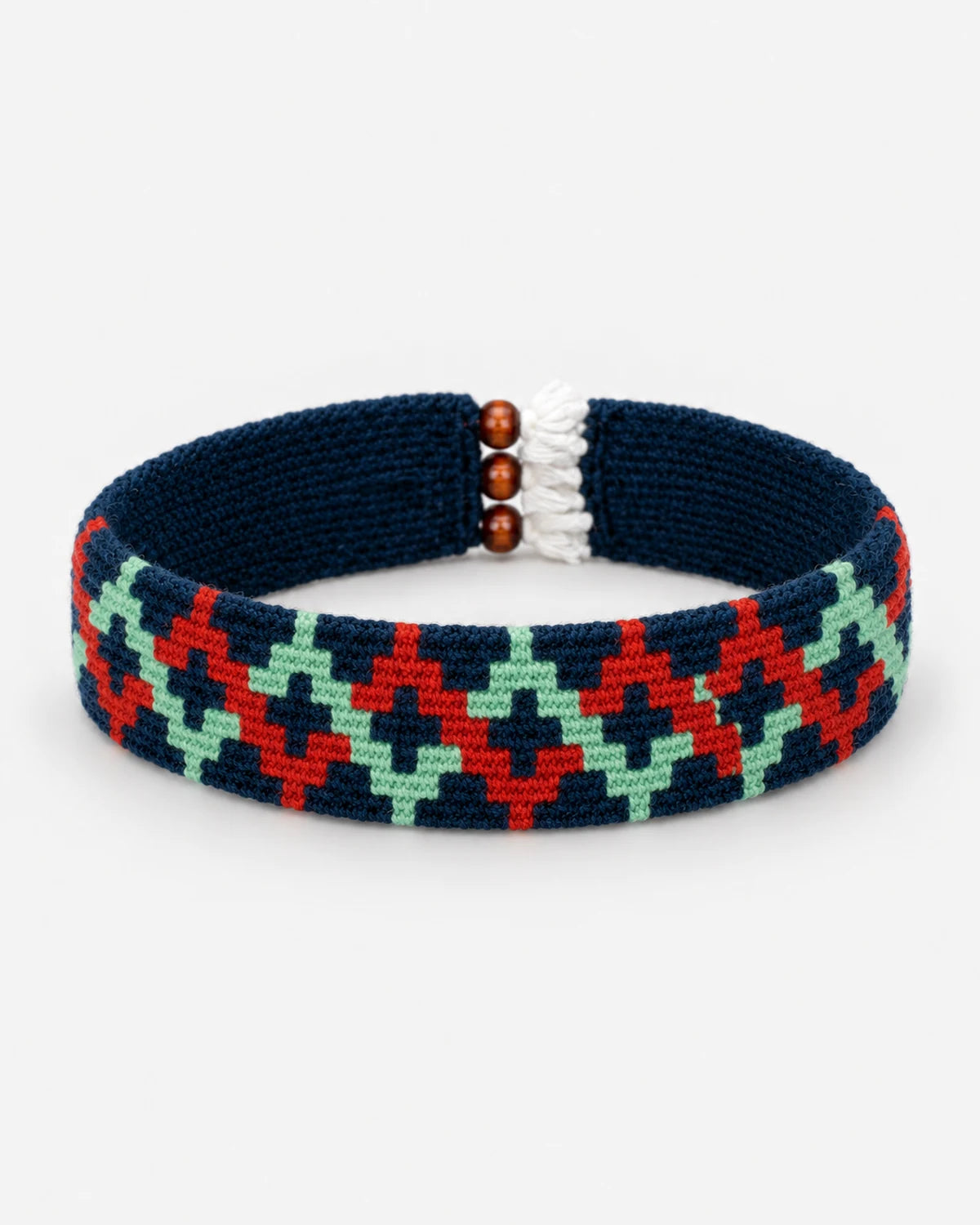 Berry Zigzag Kilim Bracelet with mint-green and berry-red zigzags on a navy woven band, shown in a curved loop.