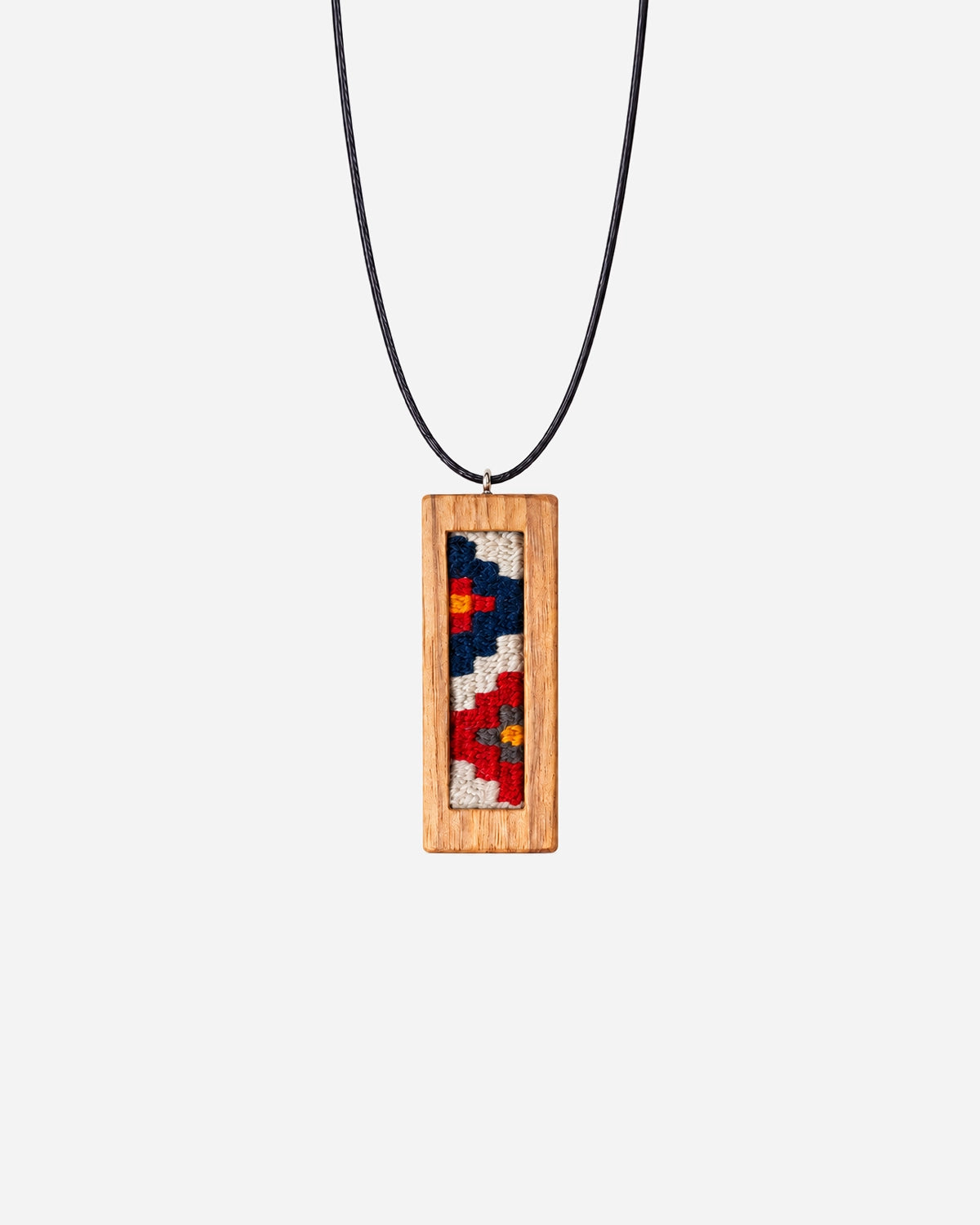 Violet Garden Kilim Necklace with navy, cream and red geometric weaving in a slim walnut frame on a black cord.